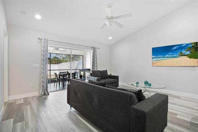 living area featuring light wood-style flooring, ceiling fan, baseboards, and lofted ceiling