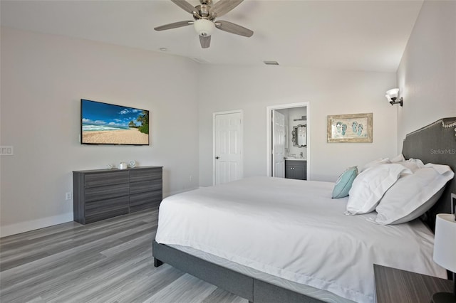 bedroom featuring ceiling fan, connected bathroom, visible vents, wood finished floors, and lofted ceiling