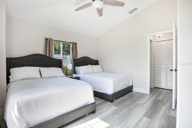 bedroom featuring visible vents, baseboards, a ceiling fan, wood finished floors, and lofted ceiling