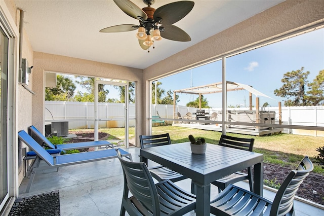 sunroom / solarium featuring outdoor dining space, a ceiling fan, and a wealth of natural light