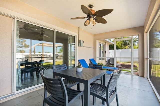 sunroom with ceiling fan and outdoor dining space