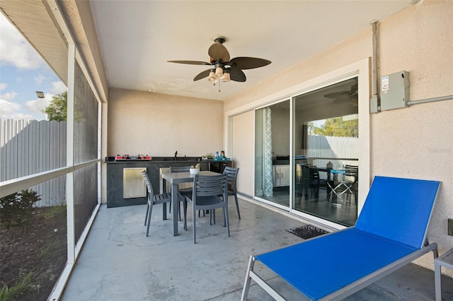 sunroom featuring outdoor dining space and a ceiling fan