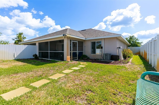 rear view of house featuring a fenced backyard, central AC, stucco siding, a lawn, and a sunroom