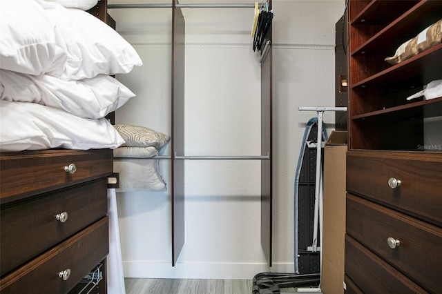 walk in closet with wood finished floors