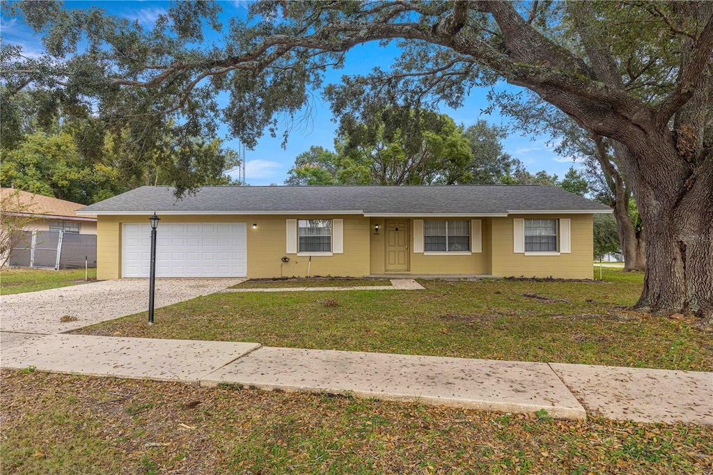 ranch-style house with a garage and a front yard