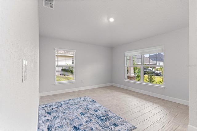 unfurnished room featuring a wealth of natural light and light wood-type flooring