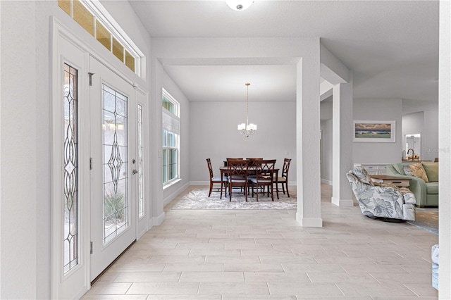 entrance foyer with an inviting chandelier and light hardwood / wood-style flooring