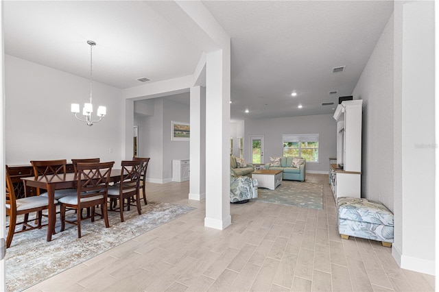 dining area featuring an inviting chandelier and light hardwood / wood-style flooring