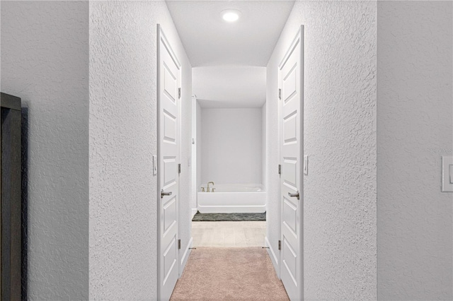 hall with light colored carpet