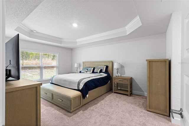 carpeted bedroom featuring ornamental molding, a textured ceiling, and a tray ceiling