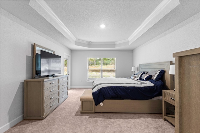 carpeted bedroom with a textured ceiling, crown molding, and a tray ceiling