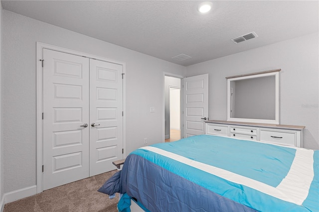 bedroom featuring carpet flooring, a textured ceiling, and a closet