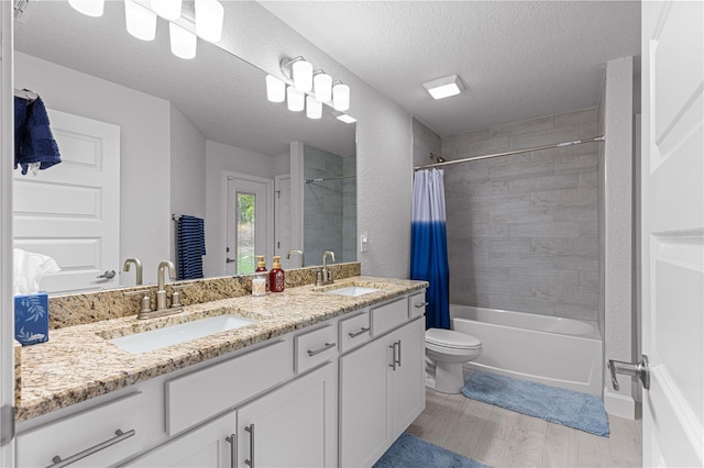 full bathroom featuring shower / tub combo, a textured ceiling, wood-type flooring, vanity, and toilet