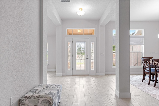 entrance foyer with a textured ceiling and light hardwood / wood-style flooring