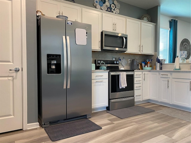 kitchen featuring light hardwood / wood-style floors, white cabinetry, backsplash, and appliances with stainless steel finishes