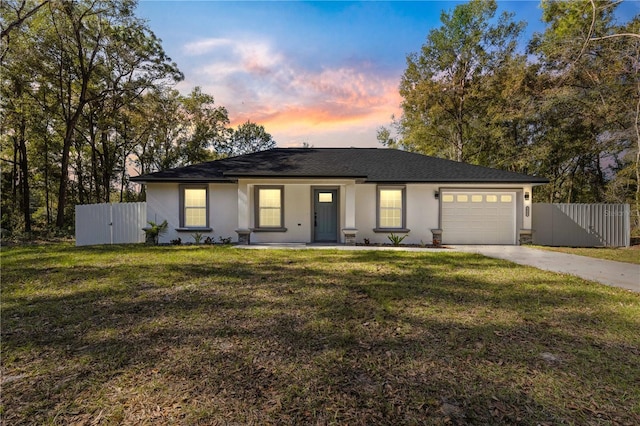 ranch-style house featuring a garage, a lawn, and covered porch