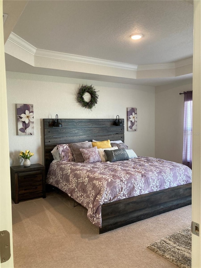 bedroom with a raised ceiling, carpet, and ornamental molding