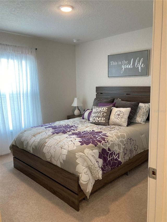 carpeted bedroom featuring a textured ceiling