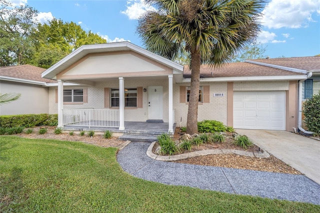 view of front of property featuring covered porch, a garage, and a front lawn