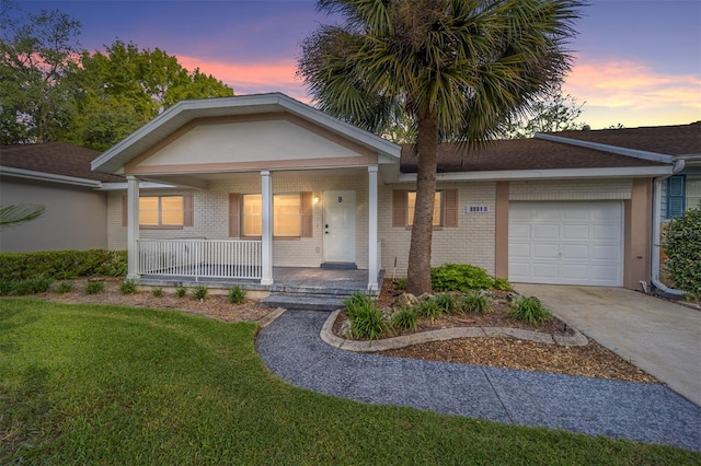 view of front of home featuring a garage, a lawn, and a porch