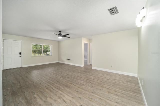 unfurnished living room featuring a textured ceiling, ceiling fan, and light hardwood / wood-style floors