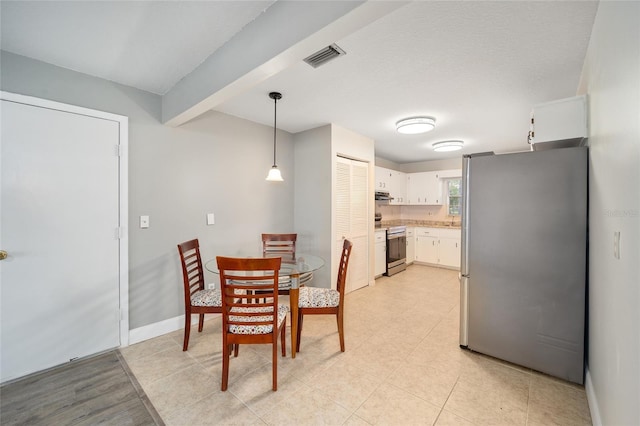 dining space with beam ceiling