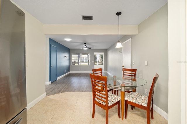 dining area featuring ceiling fan and tile patterned flooring