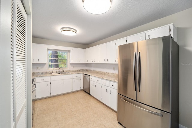 kitchen with sink, white cabinetry, appliances with stainless steel finishes, and a textured ceiling