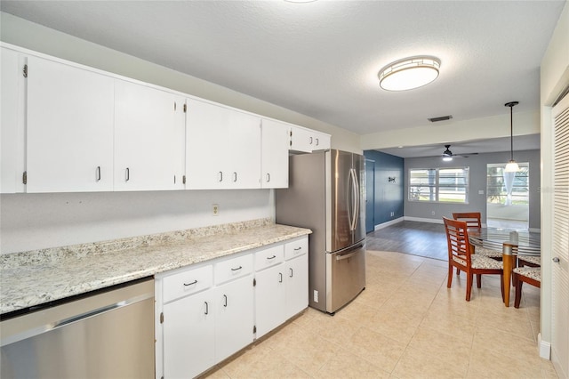 kitchen featuring a textured ceiling, white cabinets, appliances with stainless steel finishes, decorative light fixtures, and ceiling fan