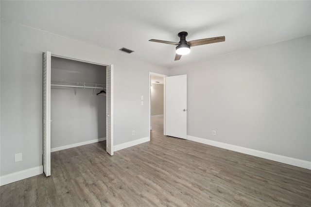 unfurnished bedroom featuring ceiling fan, hardwood / wood-style floors, and a closet