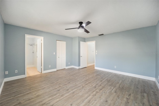 unfurnished bedroom featuring ceiling fan, connected bathroom, and light hardwood / wood-style floors