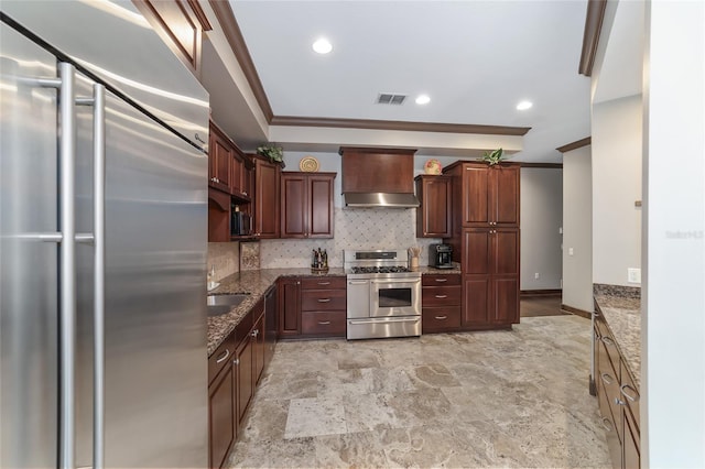 kitchen featuring premium range hood, dark stone countertops, decorative backsplash, appliances with stainless steel finishes, and ornamental molding