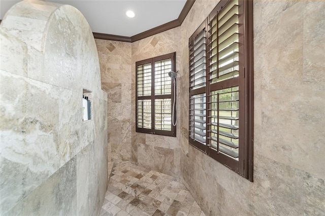 bathroom featuring a tile shower and ornamental molding