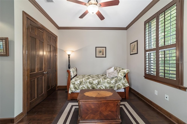 bedroom with crown molding, ceiling fan, a closet, and dark wood-type flooring