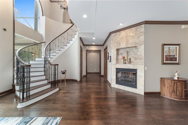 foyer entrance with a tile fireplace, dark hardwood / wood-style flooring, and ornamental molding