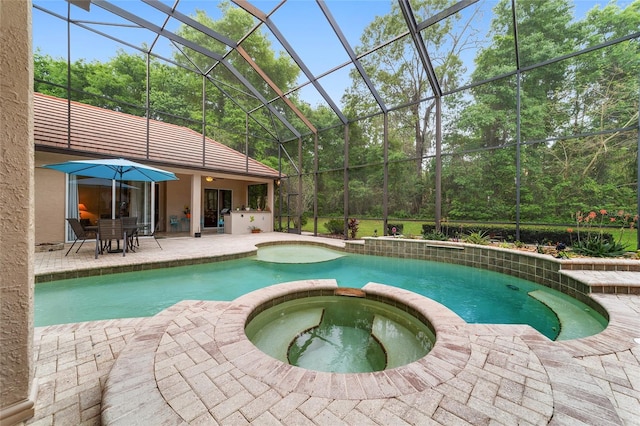 view of swimming pool featuring glass enclosure, an in ground hot tub, and a patio area