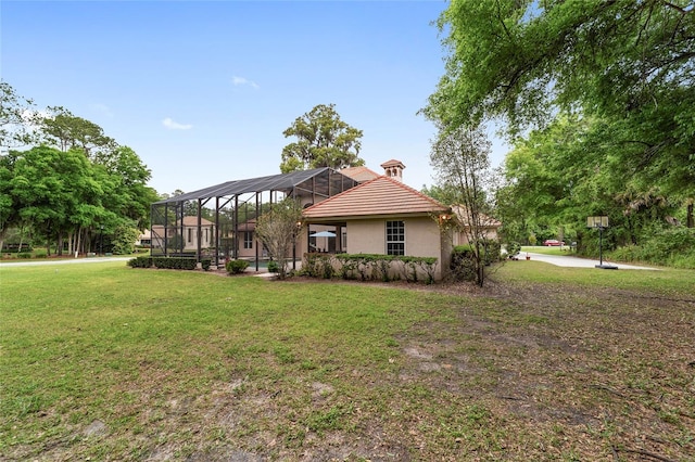 view of front of property with glass enclosure and a front lawn