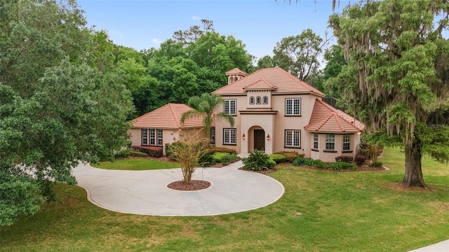 mediterranean / spanish house featuring a front lawn