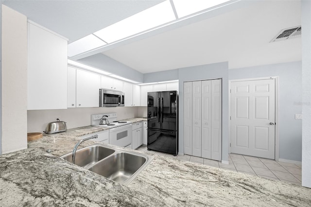 kitchen featuring black refrigerator, sink, light tile patterned floors, white cabinets, and white range with electric cooktop