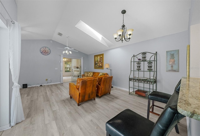 living room featuring lofted ceiling with skylight, light hardwood / wood-style flooring, and ceiling fan with notable chandelier