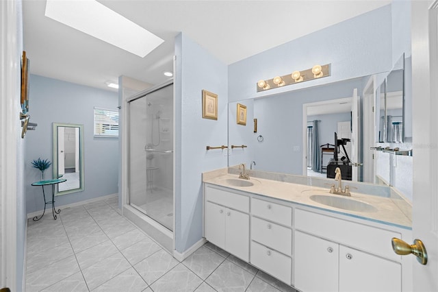 bathroom featuring vanity, a skylight, and a shower with door