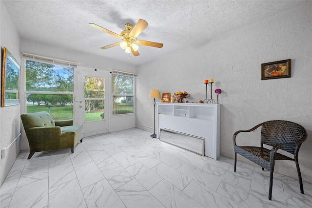 living area featuring a textured ceiling and ceiling fan