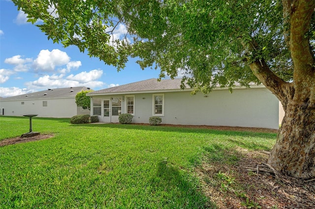 rear view of house featuring a lawn