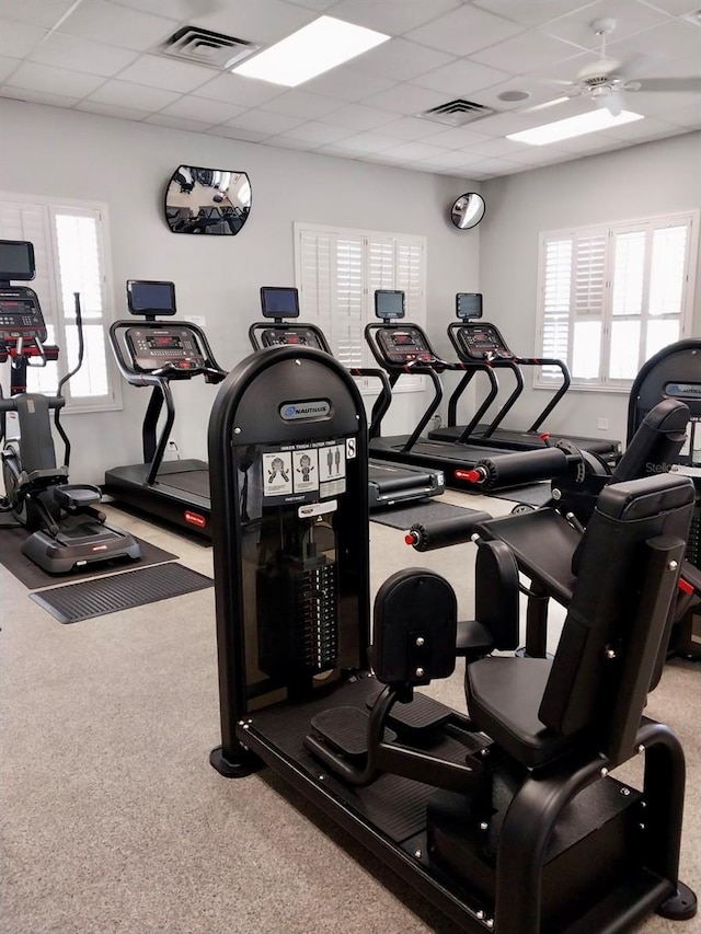 exercise room featuring a paneled ceiling, plenty of natural light, and ceiling fan