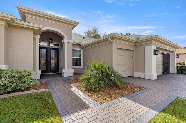 entrance to property featuring a garage and french doors