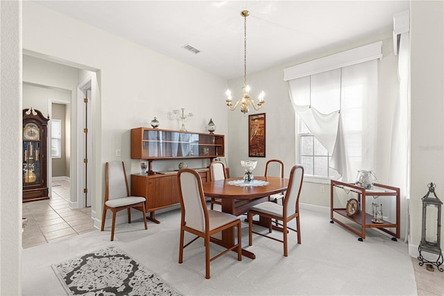 dining space with a notable chandelier and light tile patterned flooring