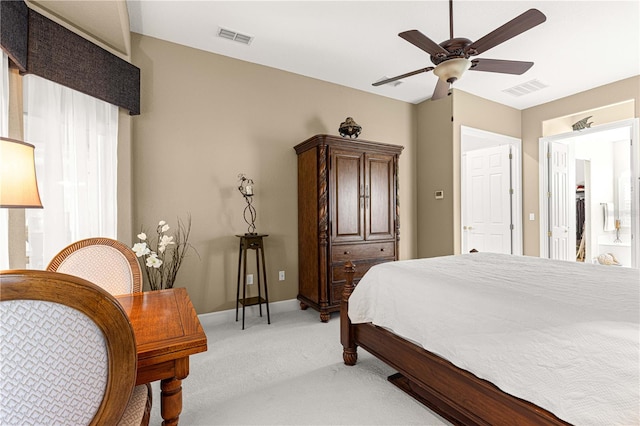 carpeted bedroom with ensuite bathroom and ceiling fan