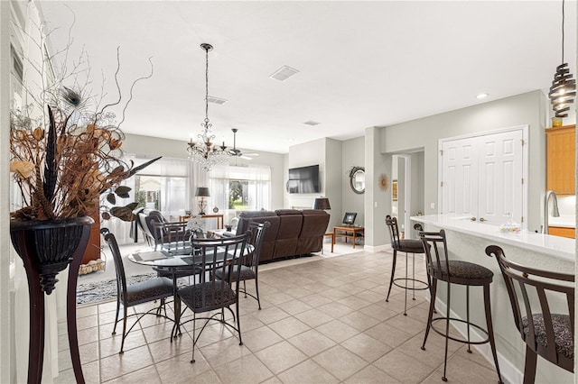 tiled dining room featuring ceiling fan with notable chandelier