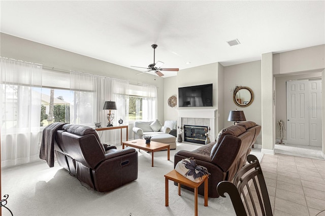 living room with light tile patterned flooring, a tile fireplace, and ceiling fan