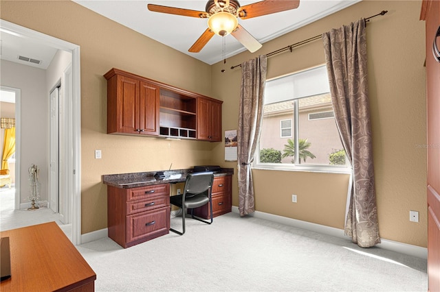 office featuring light colored carpet, ceiling fan, and built in desk